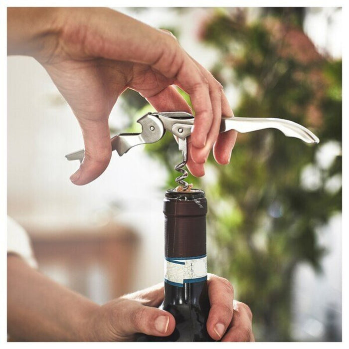 a classic corkscrew with a wooden handle and a metallic spiral. The corkscrew is shown in mid-air, ready to extract a cork from a wine bottle.-40531549                    