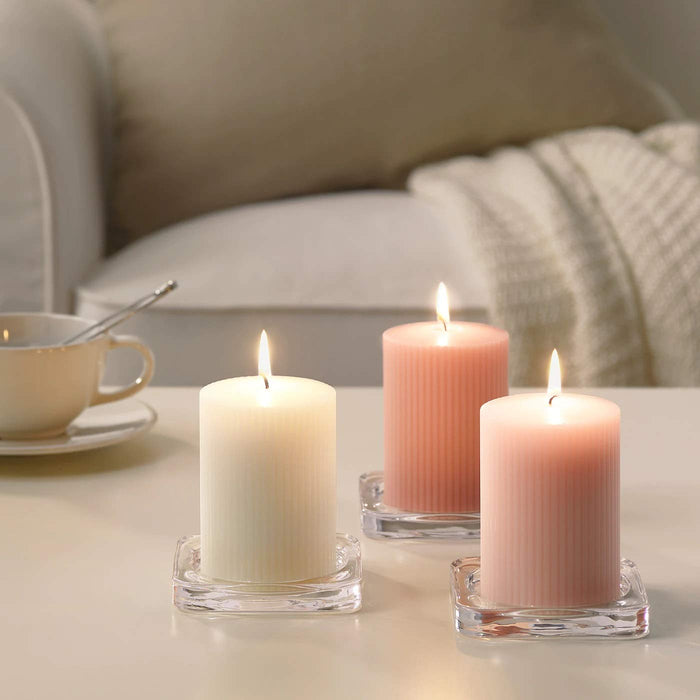 A single scented block candle from IKEA, housed in an elegant glass holder with a stylish design.