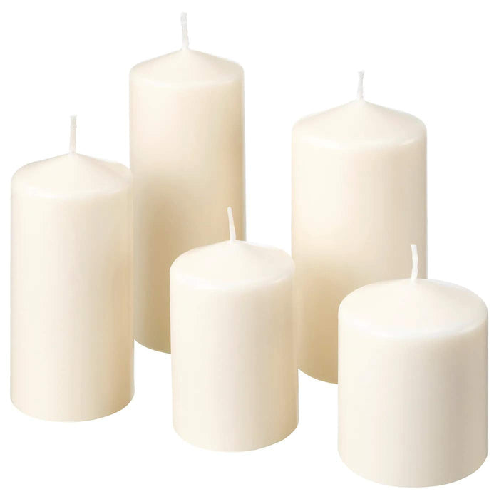 A white unscented block candle from IKEA, placed on a candle holder, creating a cozy and comfortable atmosphere.
