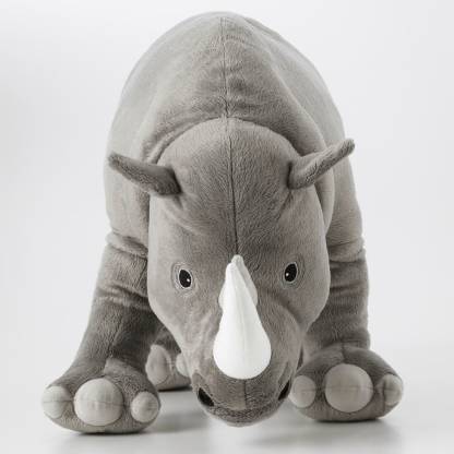 The IKEA Soft Toy Rhino sitting on a bed, ready for a cozy bedtime snuggle.